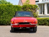 an image of a red convertible car parked in front of a building