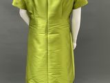 a mannequin wearing a green dress with a collared neckline