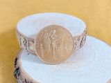 a gold coin sitting on top of a piece of wood