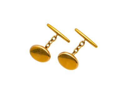 une paire de boutons de manchette en or sur fond blanc