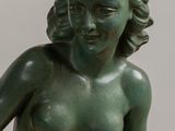 statue of a woman holding a tennis racquet in her right hand