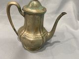 une théière en laiton ancien sur fond blanc