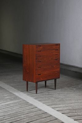 une petite commode posée sur un parquet