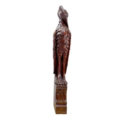 sculpture en bois représentant un oiseau sur un socle, sur fond blanc