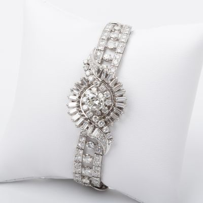 a close up of a diamond and white gold bracelet on a pillow