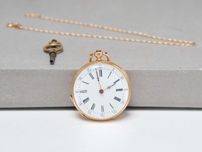 an image of a gold pocket watch sitting on top of a box