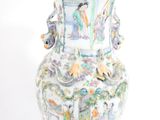 a vase with a painting on it sitting on a table