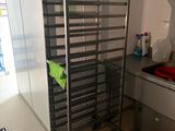 une photo d'une cuisine avec une étagère métallique dans un coin