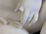 a white statue of a woman holding a man ' s hand