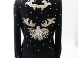 the back of a black jacket with gold and silver sequins on it
