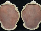 pair of antique brass framed mirrors on a black background