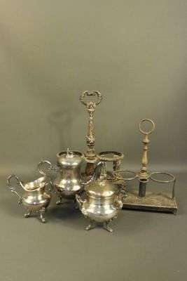 a silver tea set sitting on a table next to a pair of scissors