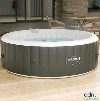 un jacuzzi gonflable installé sur une terrasse, à côté d'une table et de chaises