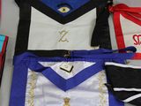 several masonic aprons are laid out on a table