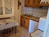 a kitchen with a table and a refrigerator in it