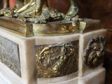 une statue d'un homme tenant une horloge au-dessus d'une table