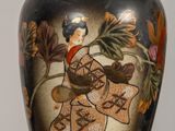 a vase with a painting on it sitting on a table
