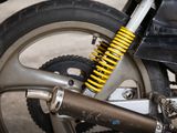 a close up of a motorcycle with a yellow shock absorbr on it ' s front wheel