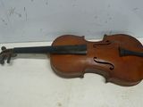 un vieux violon posé sur une table près d'un mur