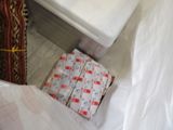 a pile of packages sitting on the floor next to a toilet