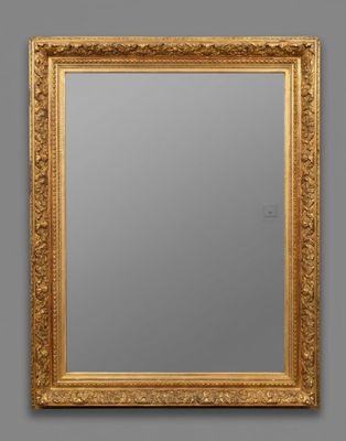 a gold framed mirror on a wall with a gray background