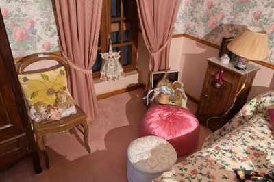 une pièce avec un lit, une chaise et une fenêtre avec des rideaux