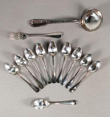 un grand nombre de cuillères et de fourchettes disposées sur la table
