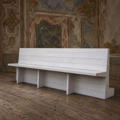 un banc blanc placé dans une pièce ornée d'une peinture murale