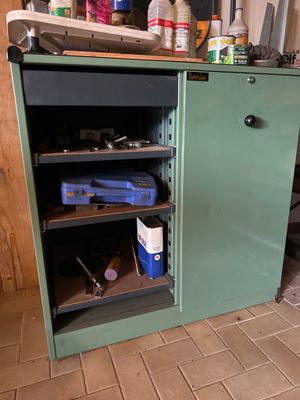 une armoire verte sur laquelle sont posés des outils