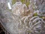 a white rose in a glass bowl on a table
