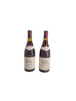 two bottles of wine sitting next to each other on a white surface