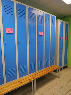 a row of blue lockers in a room with a bench