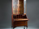 an antique secretary ' s desk with glass doors and drawers