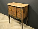 a small chest of drawers with a marble top