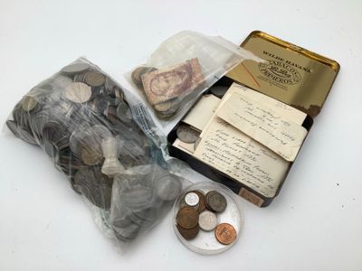 une petite boîte remplie de pièces posée sur une table, à côté d'un livre