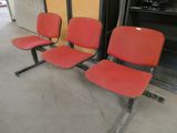 trois chaises rouges alignées dans une pièce