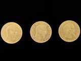 three different types of gold coins on a black background