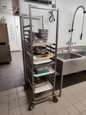 a kitchen with a sink and a rack with pans on it