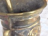 a gold mortar and a spoon sitting on a table