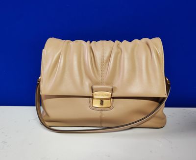 a tan leather purse sitting on top of a white table