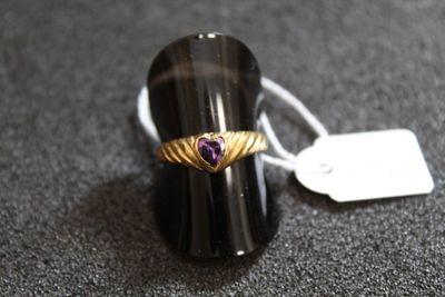 une image représentant une bague ornée d'un cœur, posée sur une table
