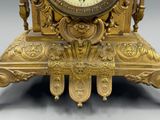a gold clock that is sitting on top of a table