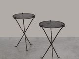 une paire de tables d'appoint en fer noir posées sur un sol en béton