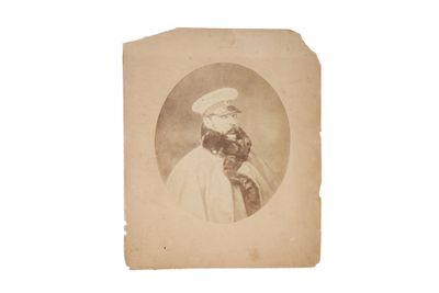 une vieille photo d'un homme vêtu d'une blouse blanche et d'un chapeau