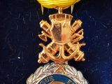 l'image d'une médaille entourée d'un ruban, sur un fond bleu