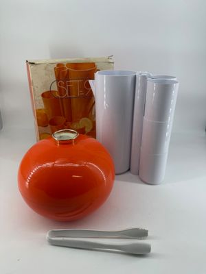 an orange vase and a pair of scissors next to it