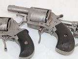 two revolvers that are sitting on a white surface