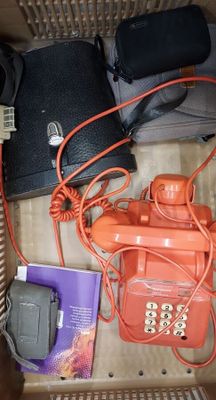 an orange phone in a box with other items