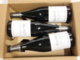 three bottles of wine in a cardboard box on a table