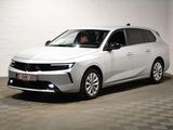 La voiture blanche est garée dans une pièce blanche au sol à carreaux.